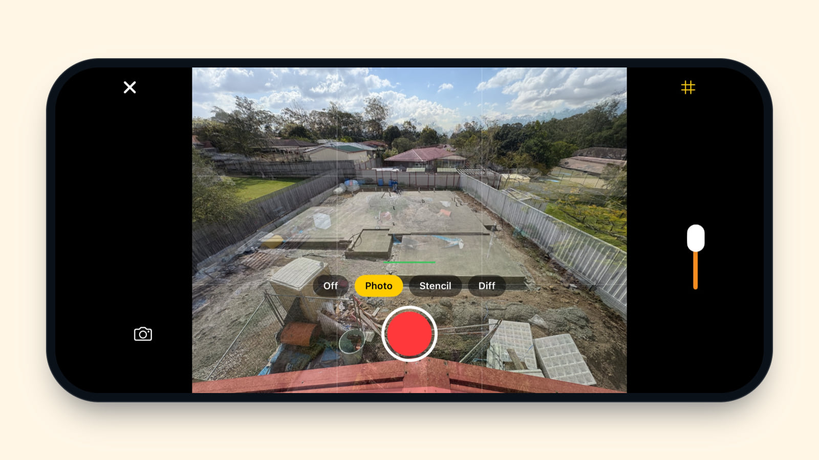 An iPhone held sideways with the camera in moment mode, as it looks in version 0.5.0: the Photo overlay still on, the key photo faint over the 9 Sep concrete slab, and a red record button
